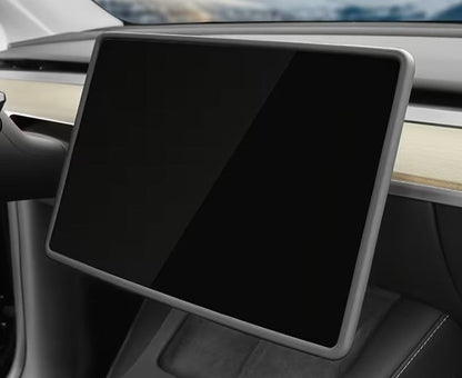 A large rectangular touchscreen display mounted on a car dashboard, shown in a close-up interior shot. The screen is black and reflective, with a silver-gray bezel, set against a gray and wood interior. TESLA_MODEL_Y_JUNIPER_TESLA_MODEL_3_HIGHLAND_16_SCREEN_YL_SCREEN_SILICONE_EDGE_PROTECTOR_BLACK_GREY_WHITE_BUY_FROM_IRELAND_AND_EUROPES_TESLARY.EU_TESLARY.FI_TESLARY.SE_TESLARY.ES_TESLARY.PT_TESLARY.CO.UK_TESLARY.IE