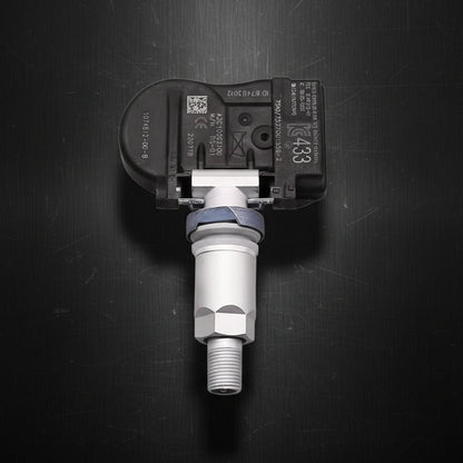 A tesla s x vehicle tire pressure sensor with a black plastic housing and a silver metal sensor body, shown against a plain white background.